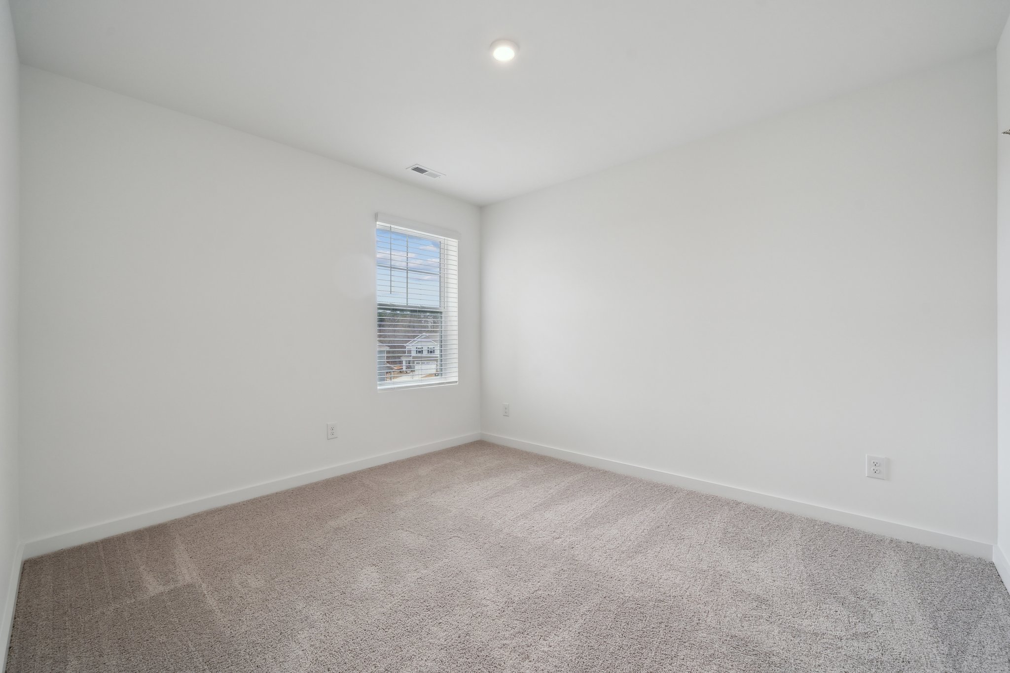 A room with a window and carpet.
