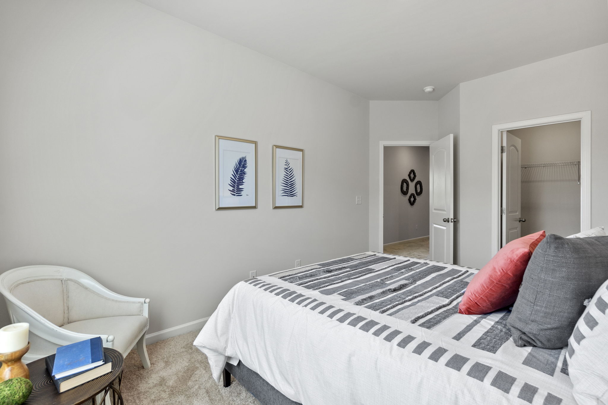 A bedroom with a bed and a chair.