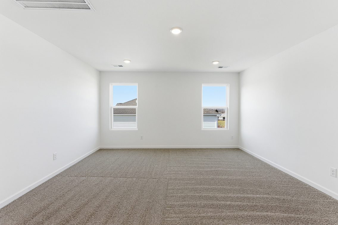 A room with a carpet and windows.