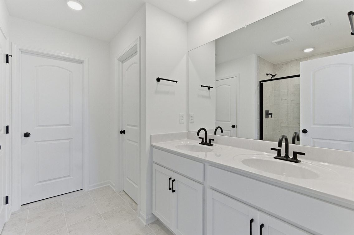A bathroom with white cabinets.