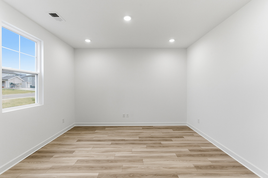 A room with a wood floor and a window.