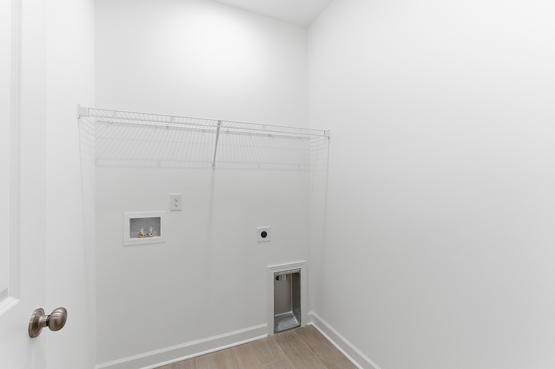 A white room with a door and a white wall.