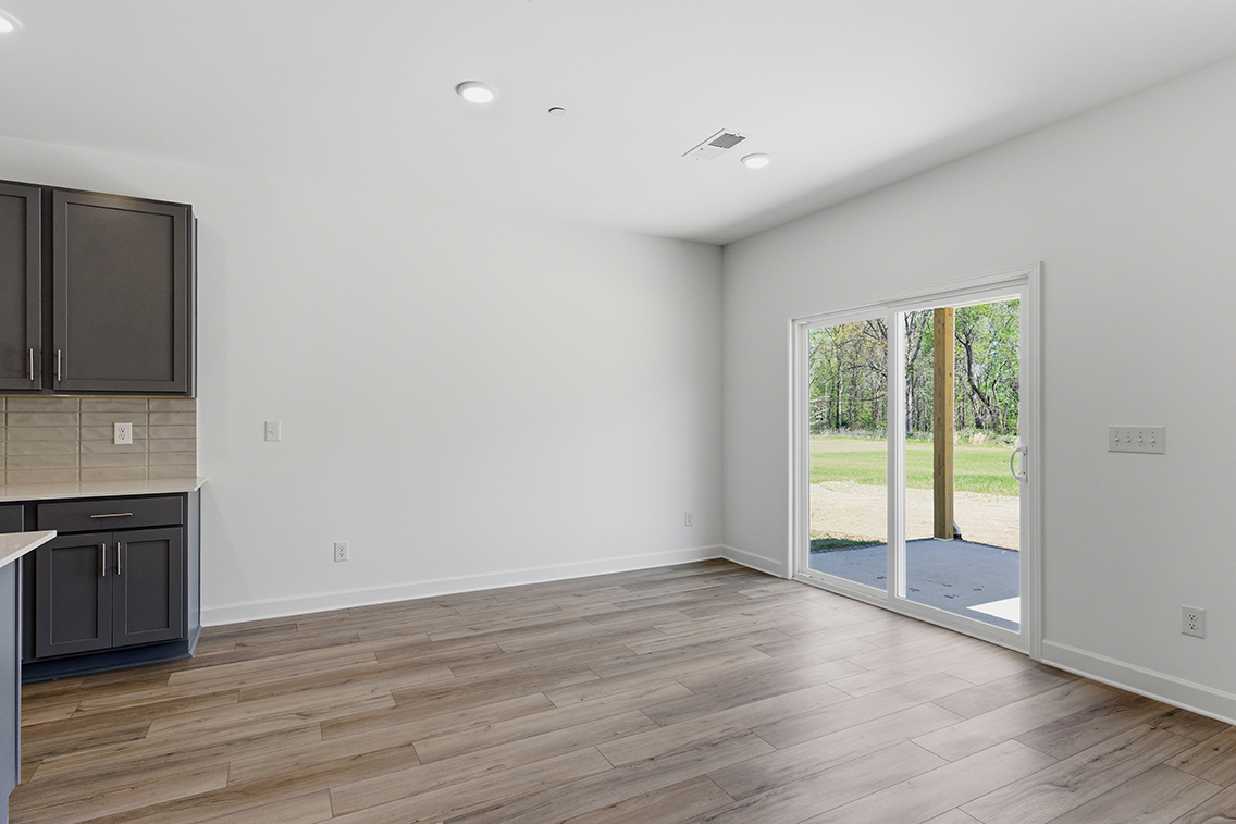 A room with a wood floor and a glass door.