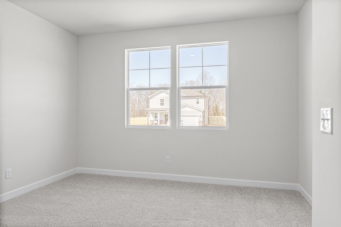 A room with a window and a carpet.