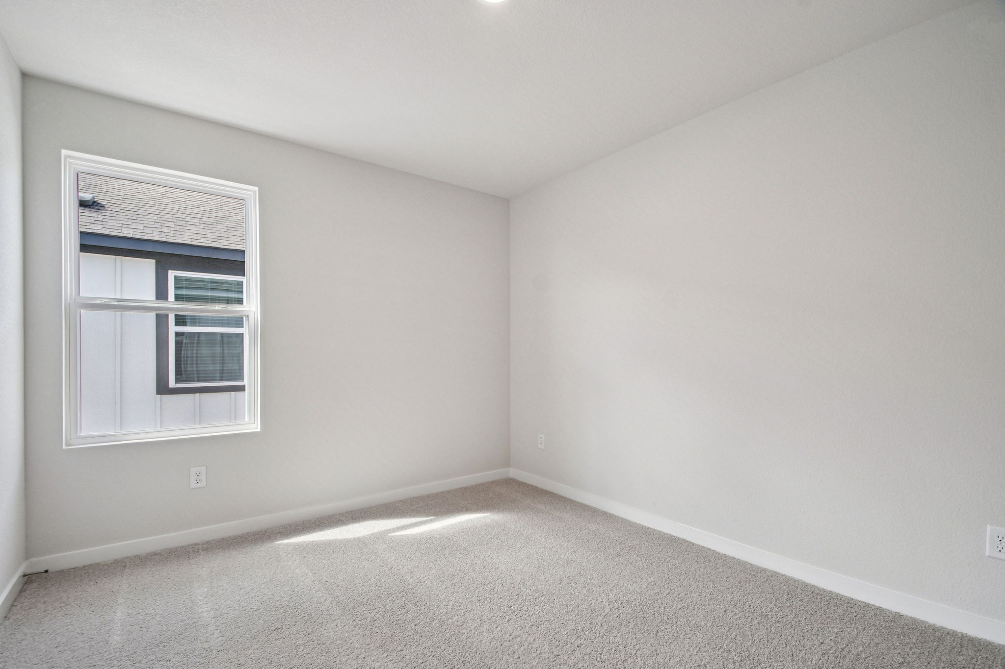 A room with a window and a carpet.