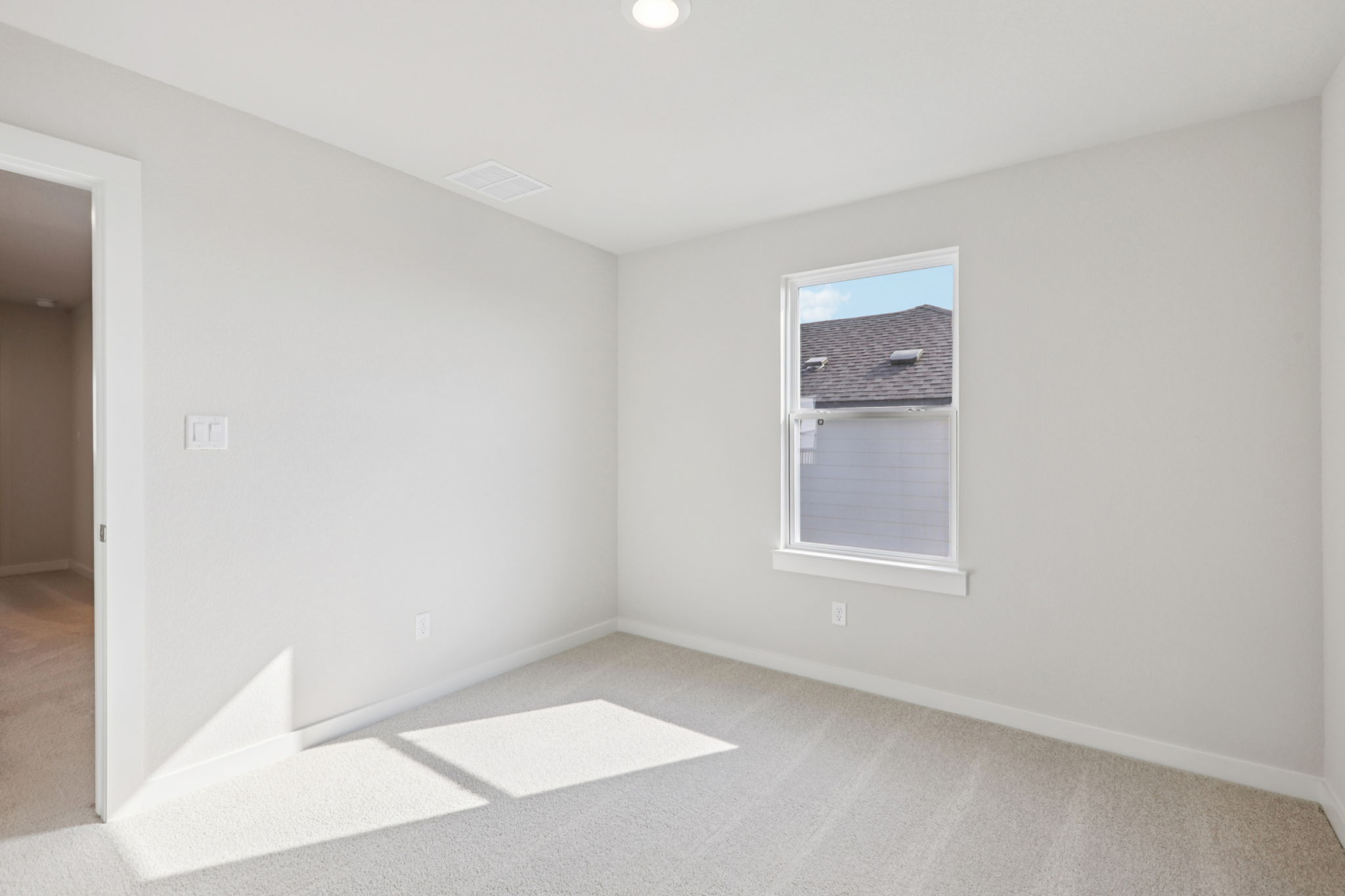 A room with a rug and a window.