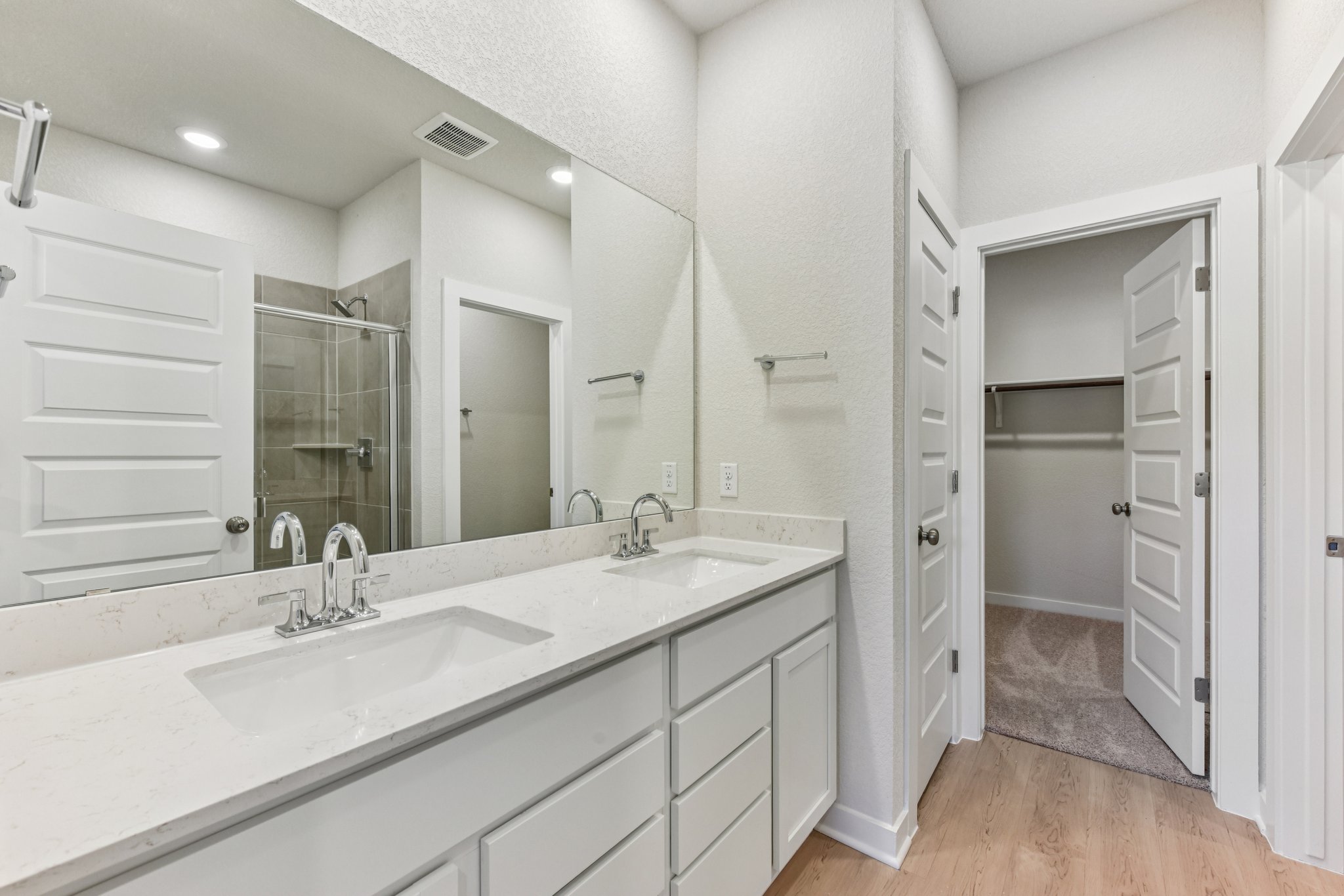 A bathroom with white cabinets.