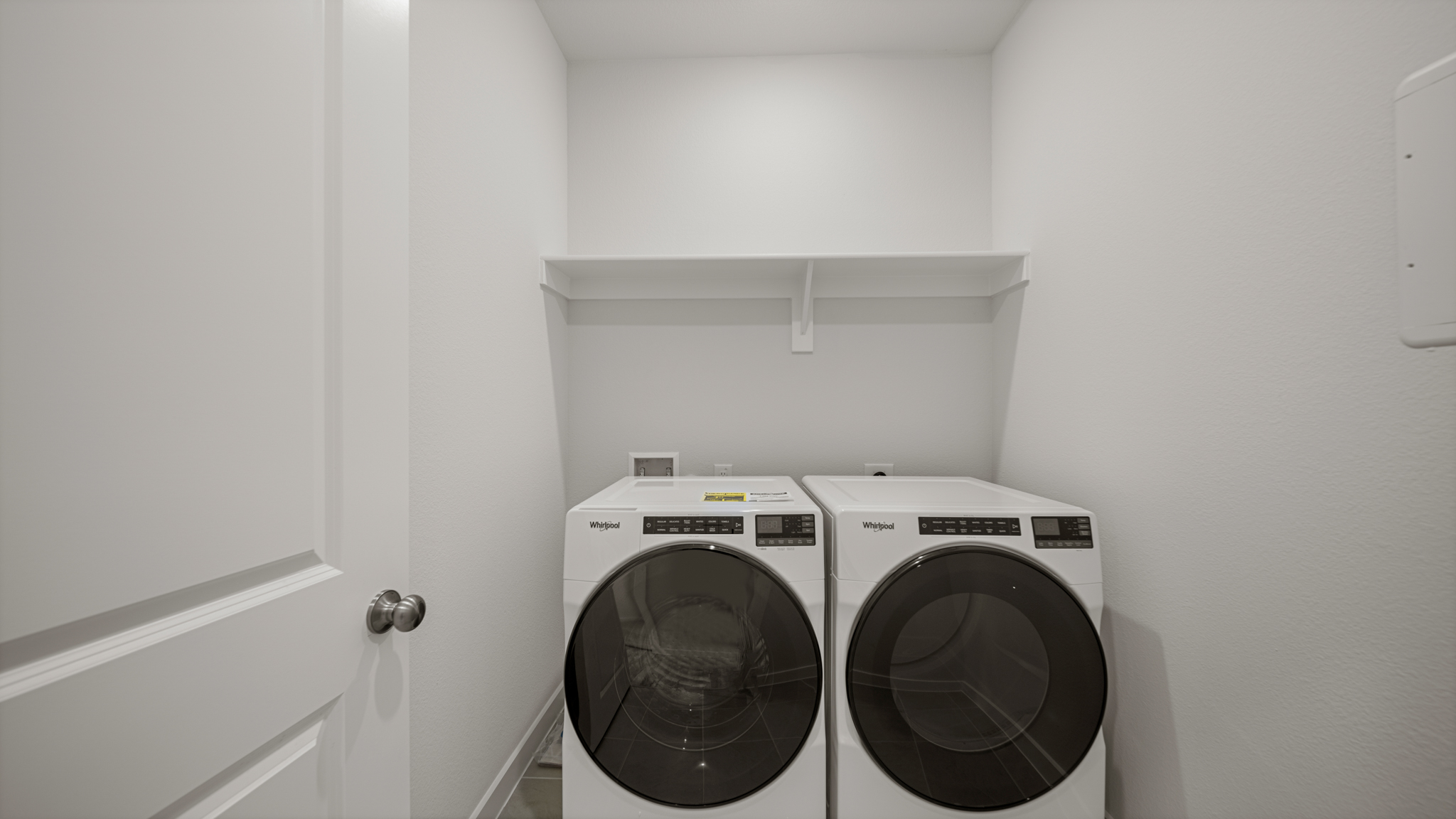 A white wall with a fan and a white door with a white door.