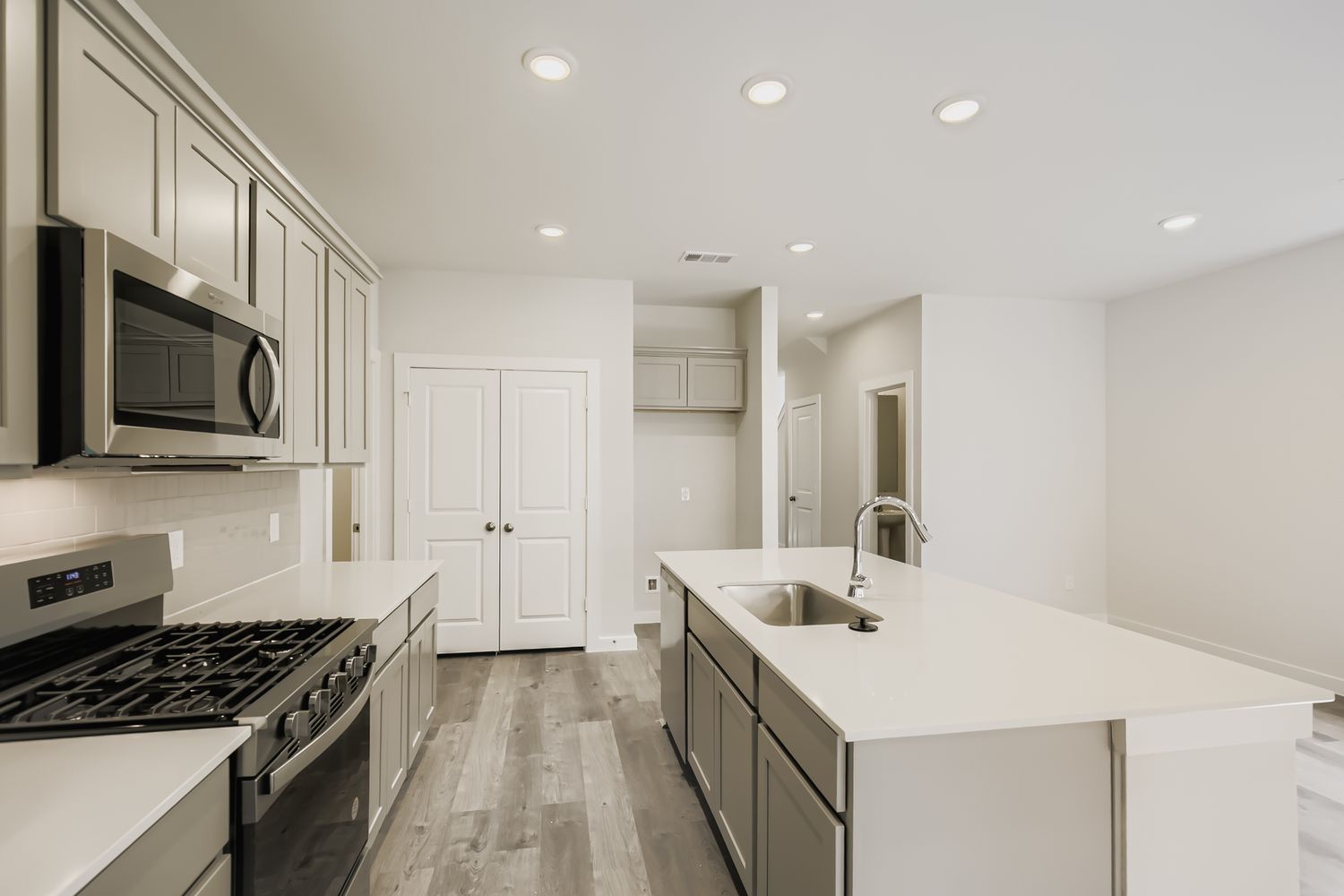 A kitchen with white cabinets.