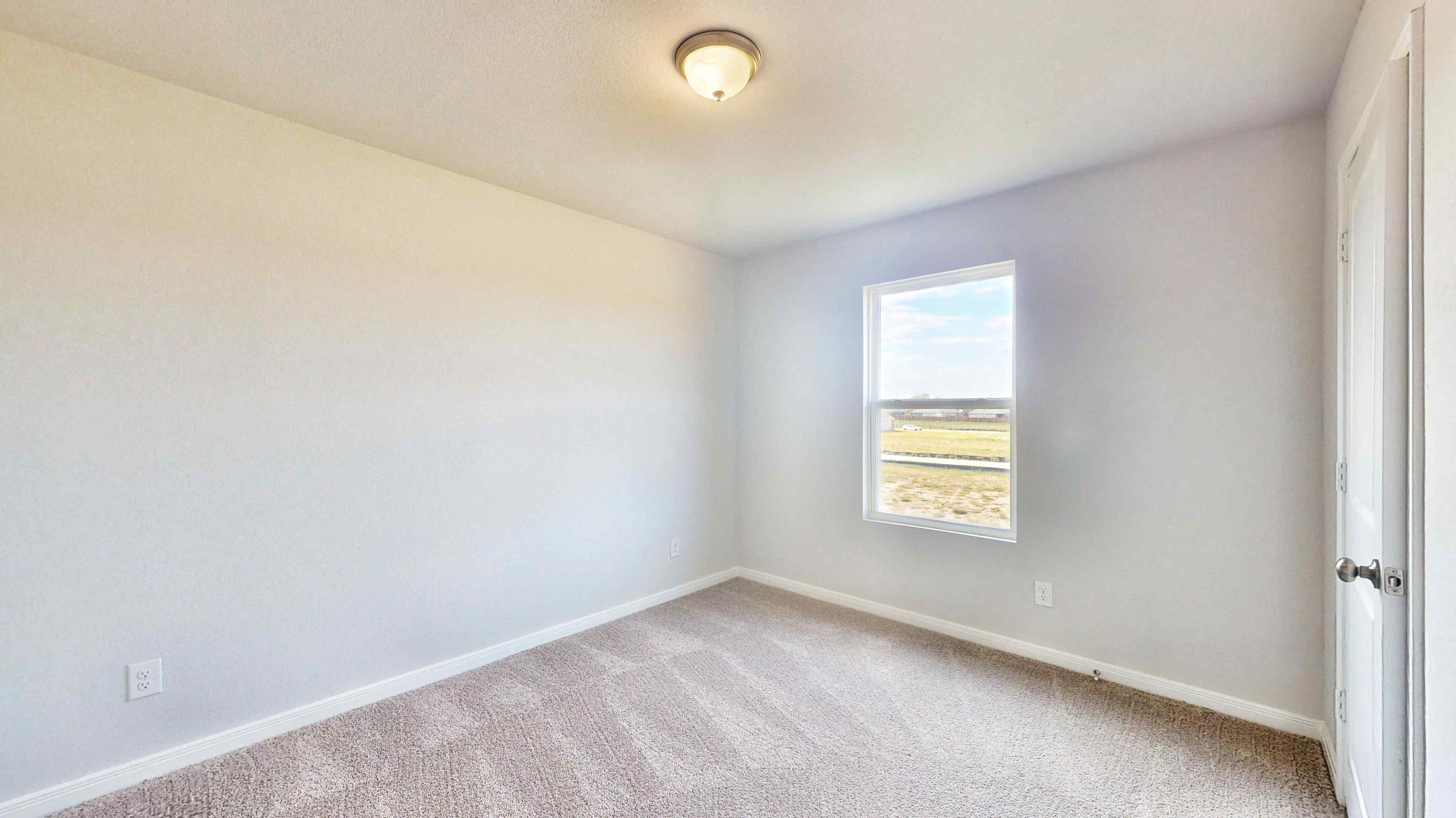 A room with a window and a carpet.