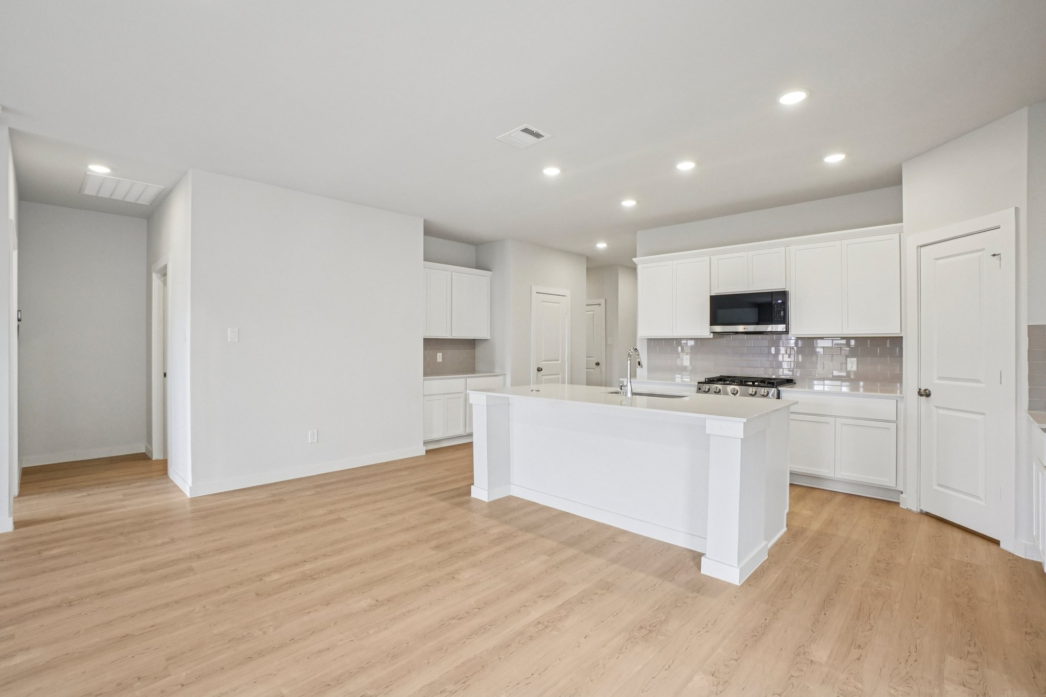 A kitchen with white cabinets.