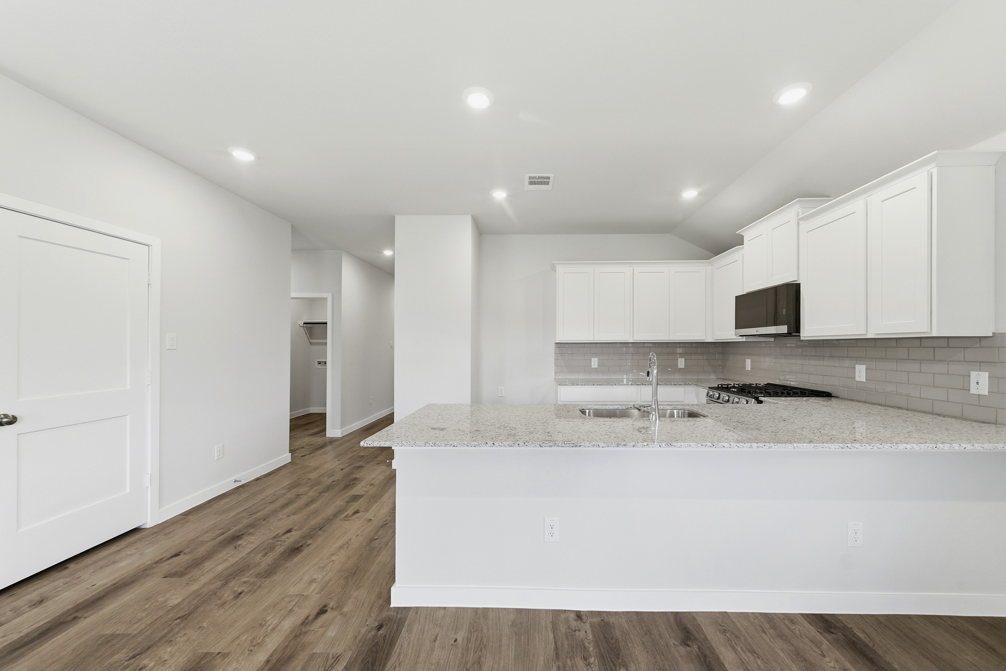 A kitchen with white cabinets.