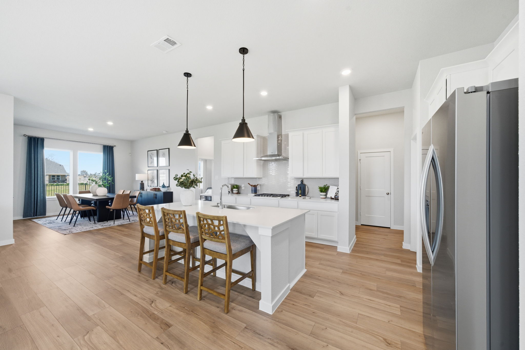A kitchen with a dining table and chairs.