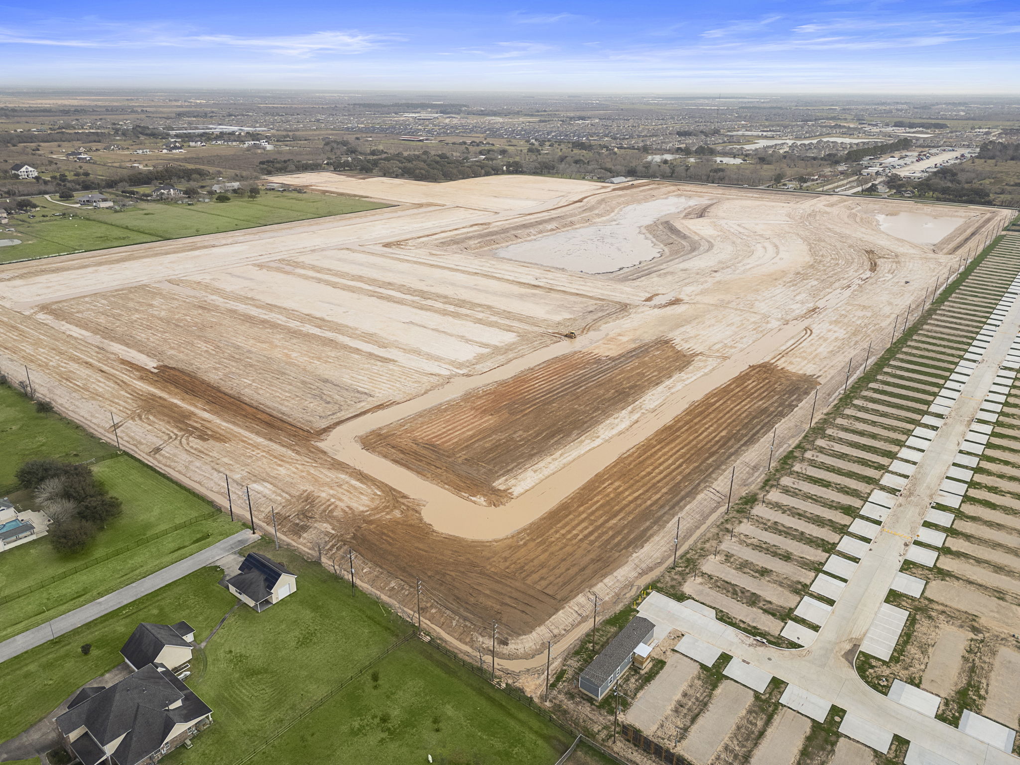 A large field with a few buildings.