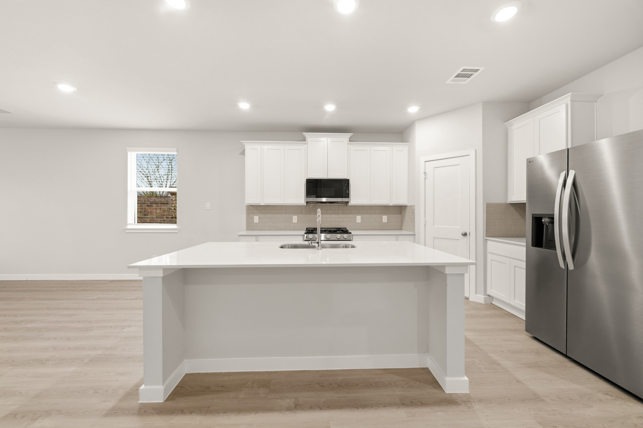 A kitchen with white cabinets.