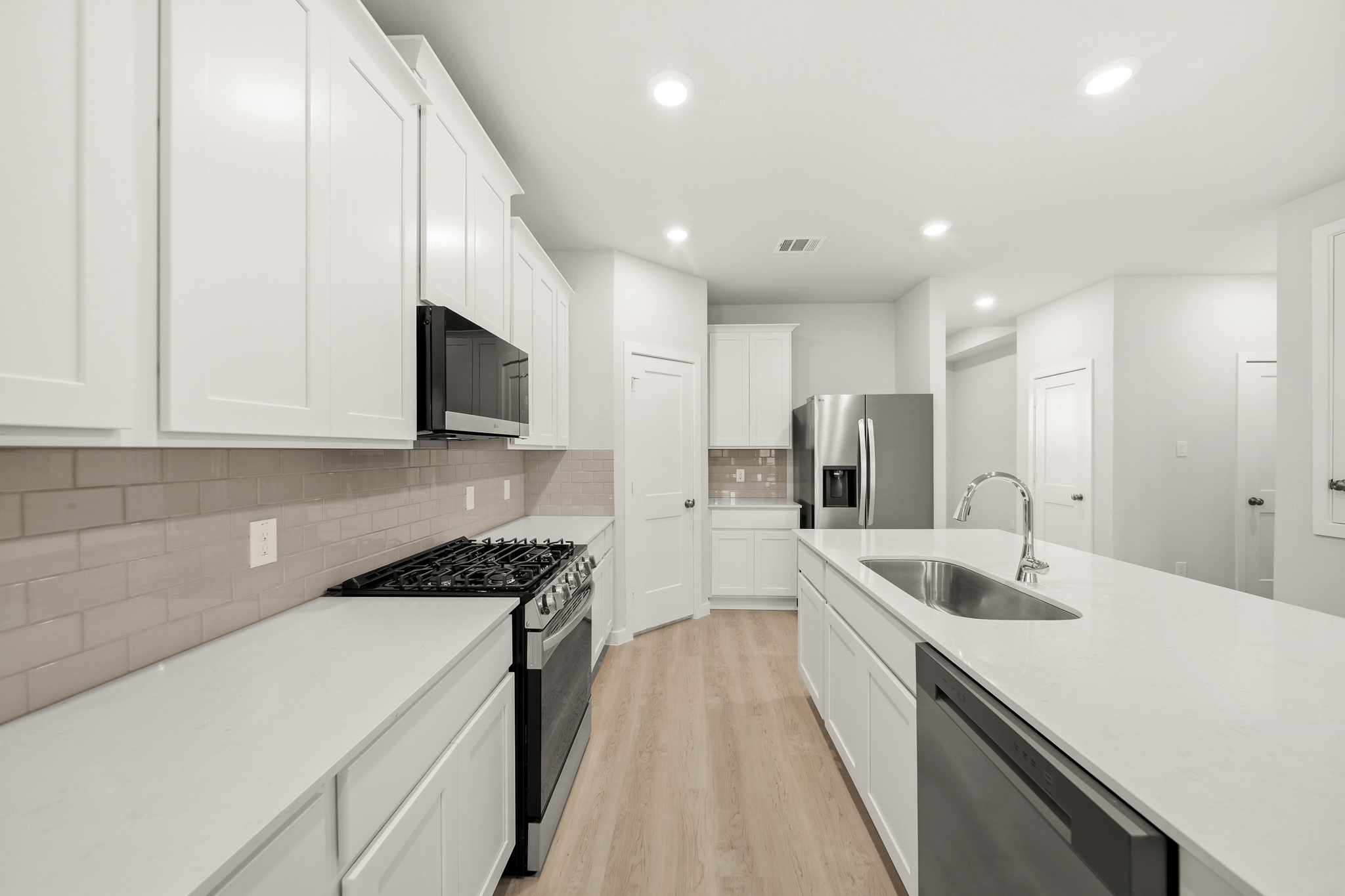 A kitchen with white cabinets.