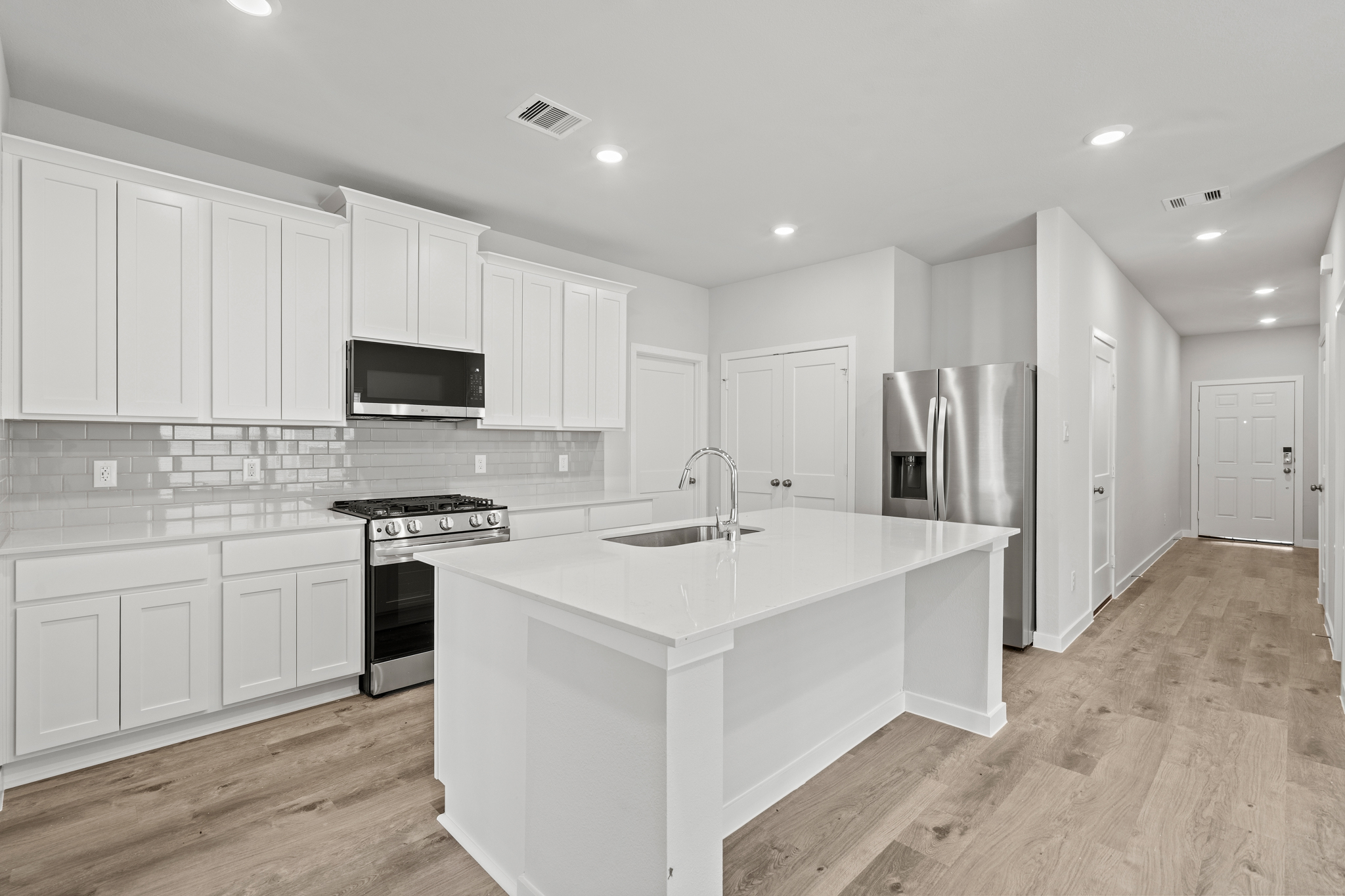 A kitchen with white cabinets.