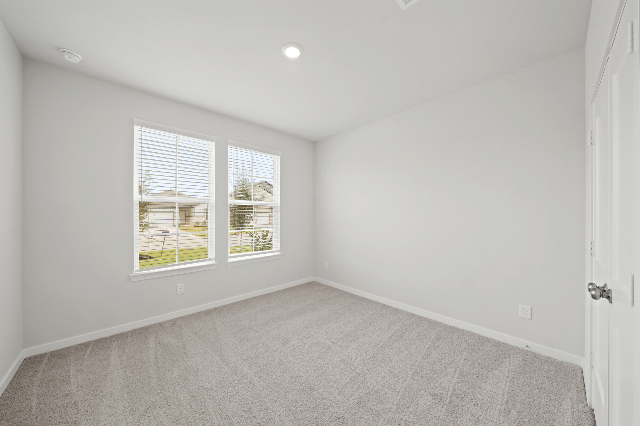 A room with a carpet and windows.