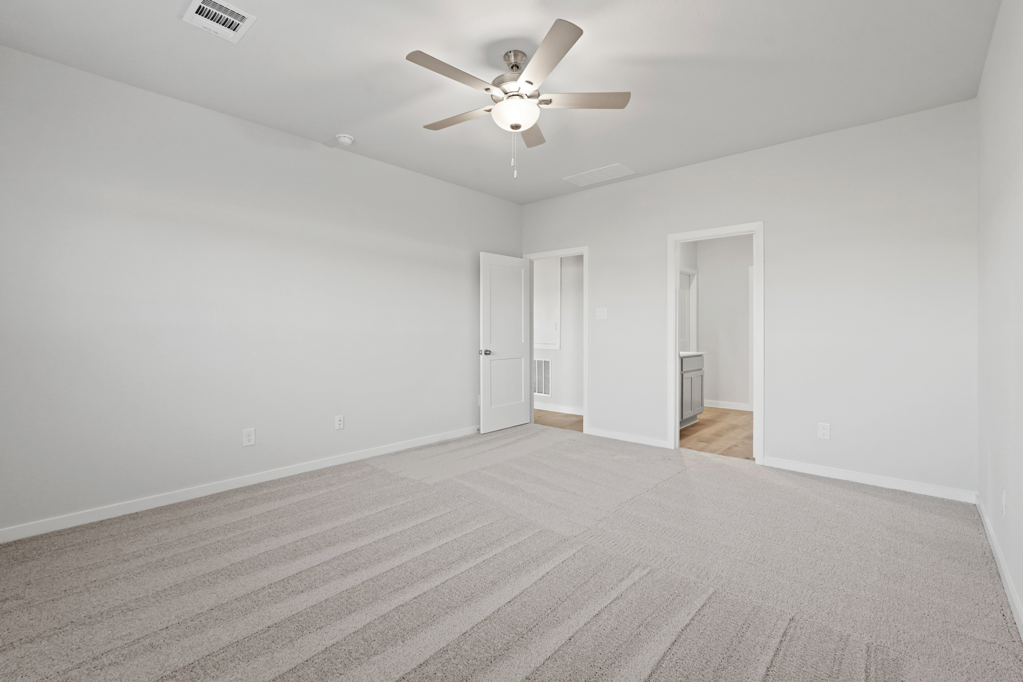 A room with a ceiling fan and a door.