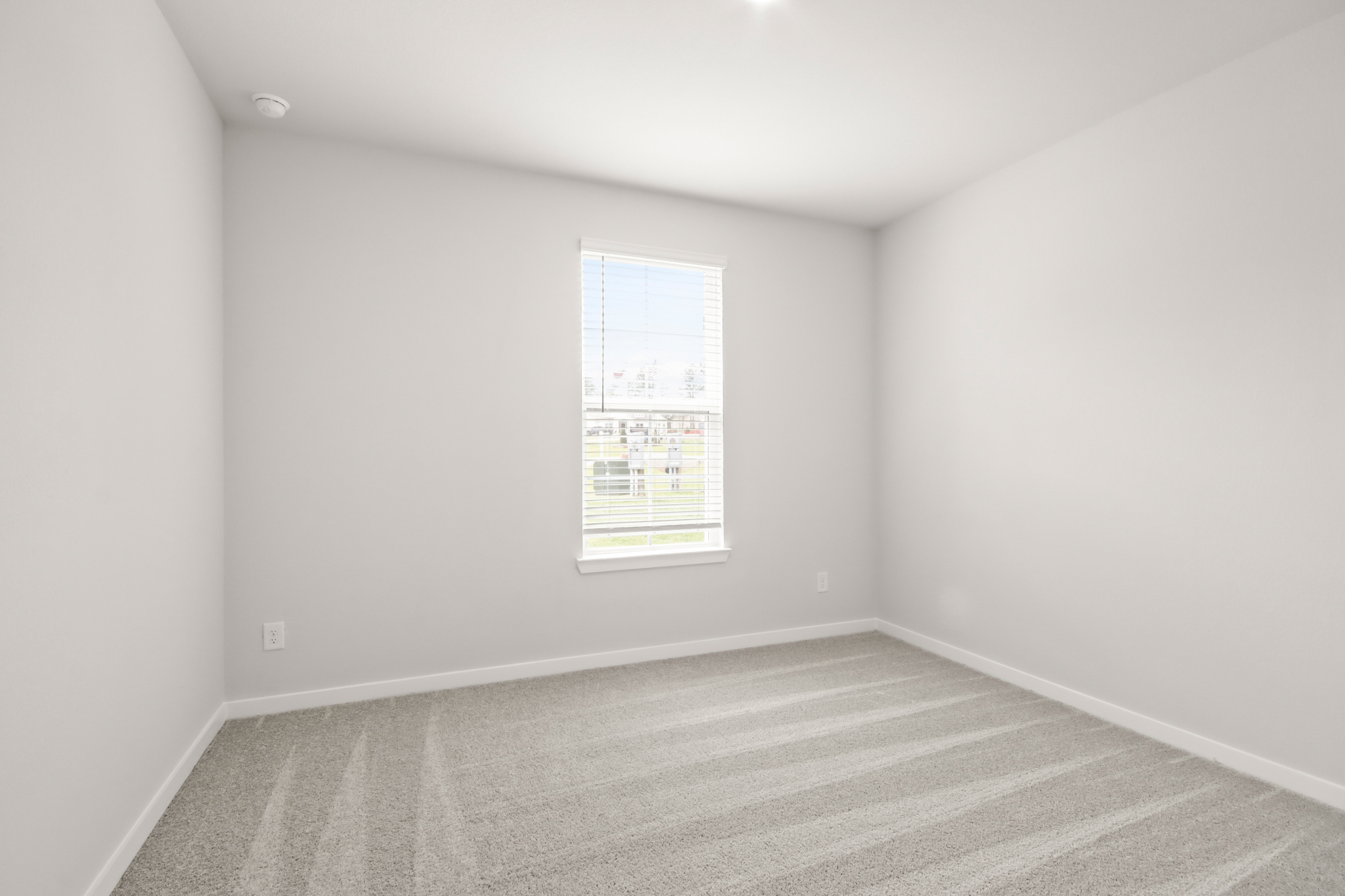 A room with a white wall and a window.