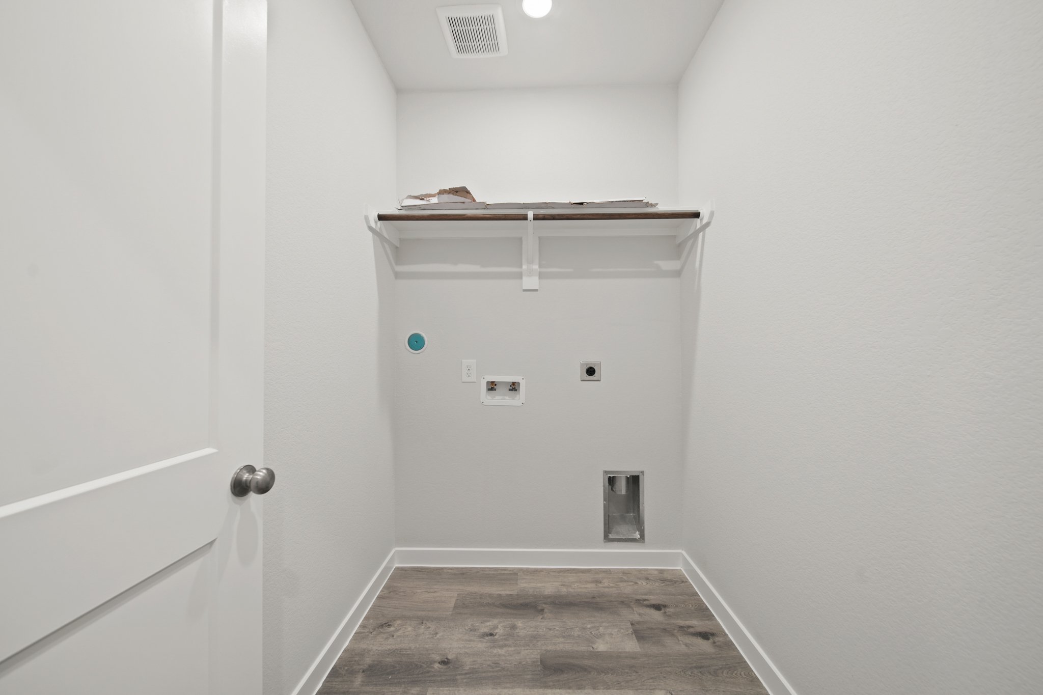 A room with a door and a shelf with a light on it.