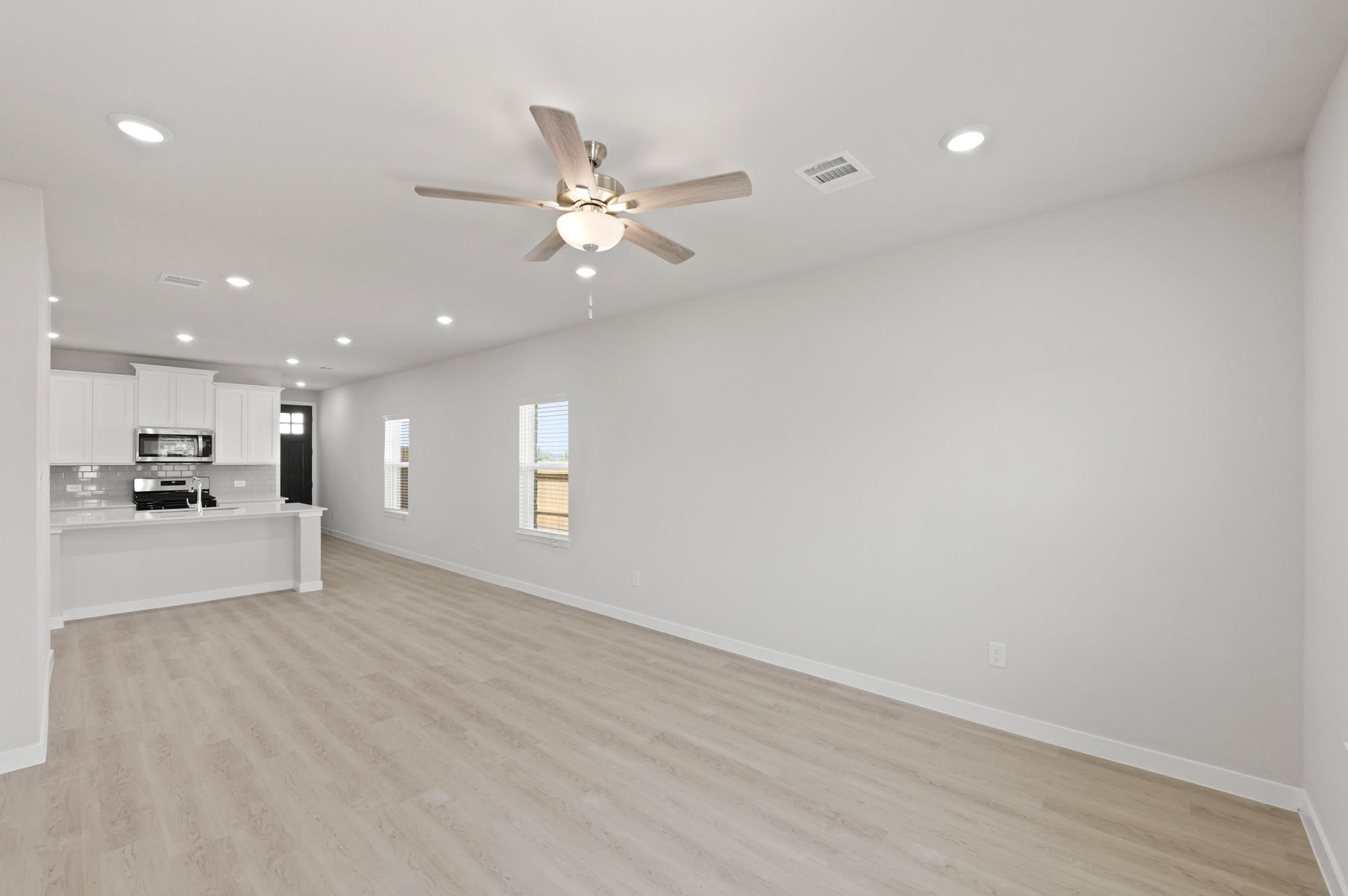 A large kitchen with a ceiling fan.
