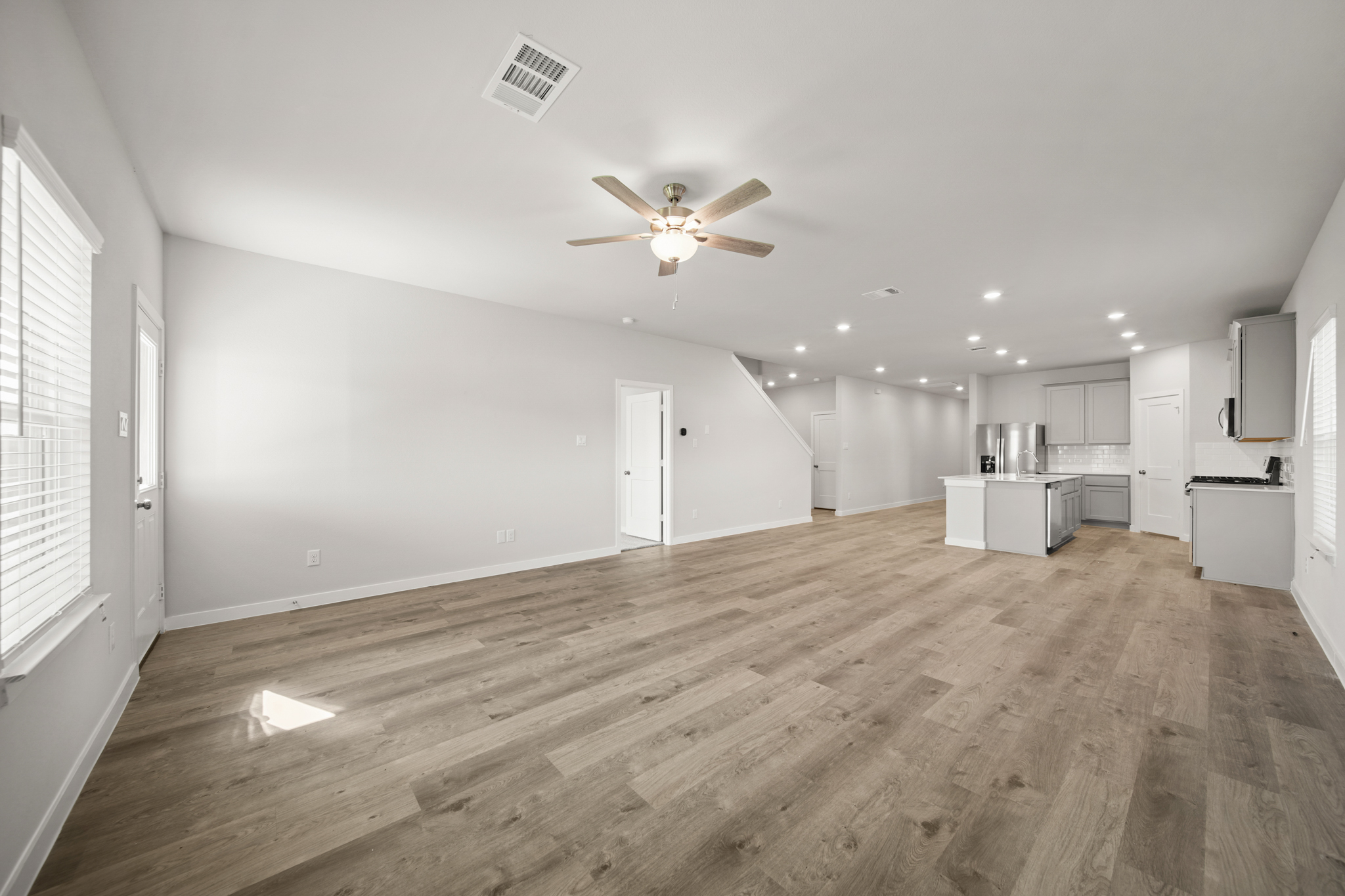 A room with a wood floor and a ceiling fan.