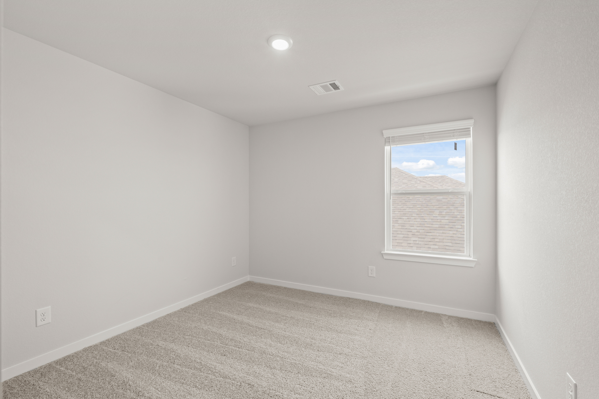 A room with a window and a carpet.