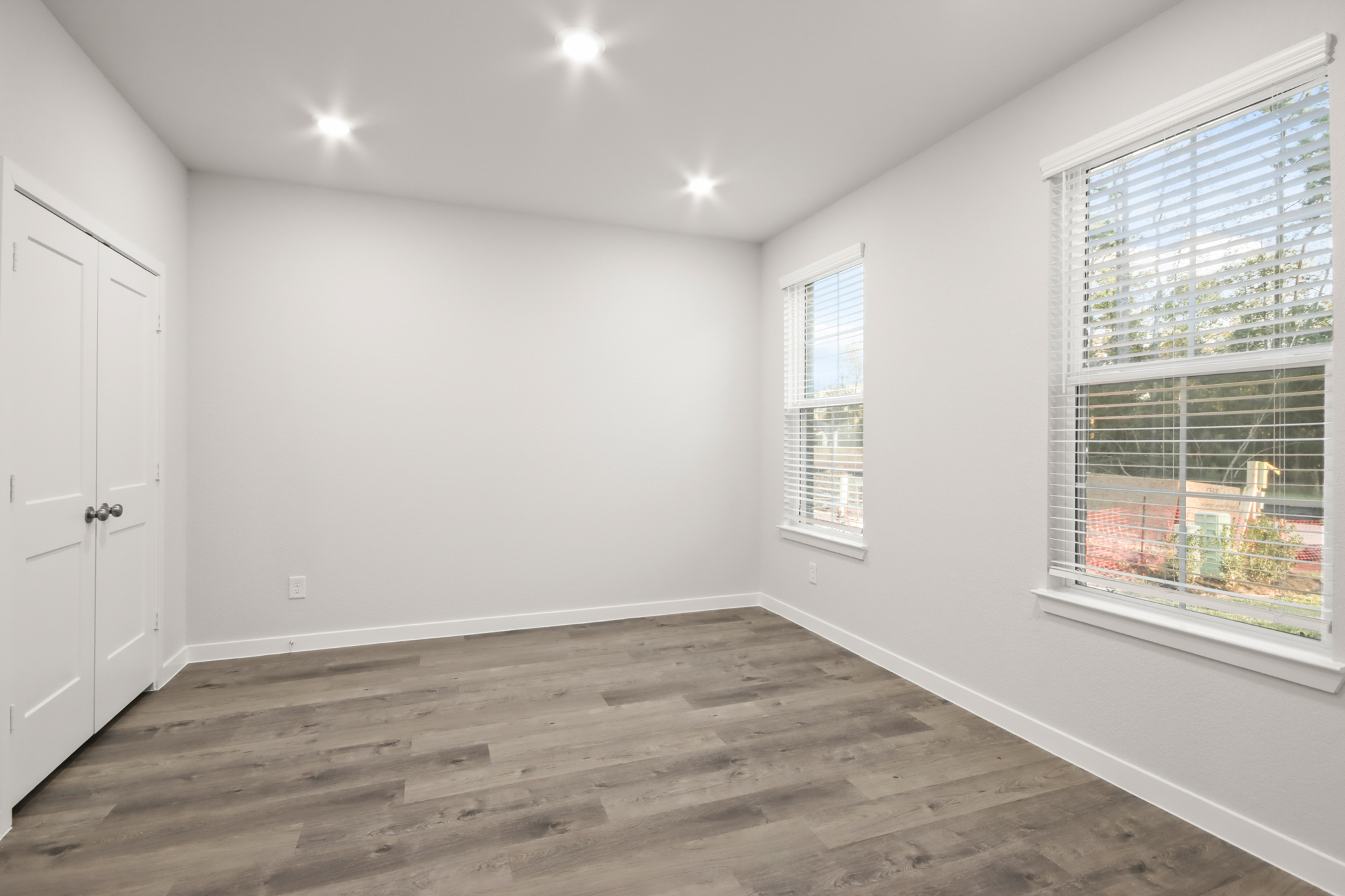 A room with a wood floor and windows.