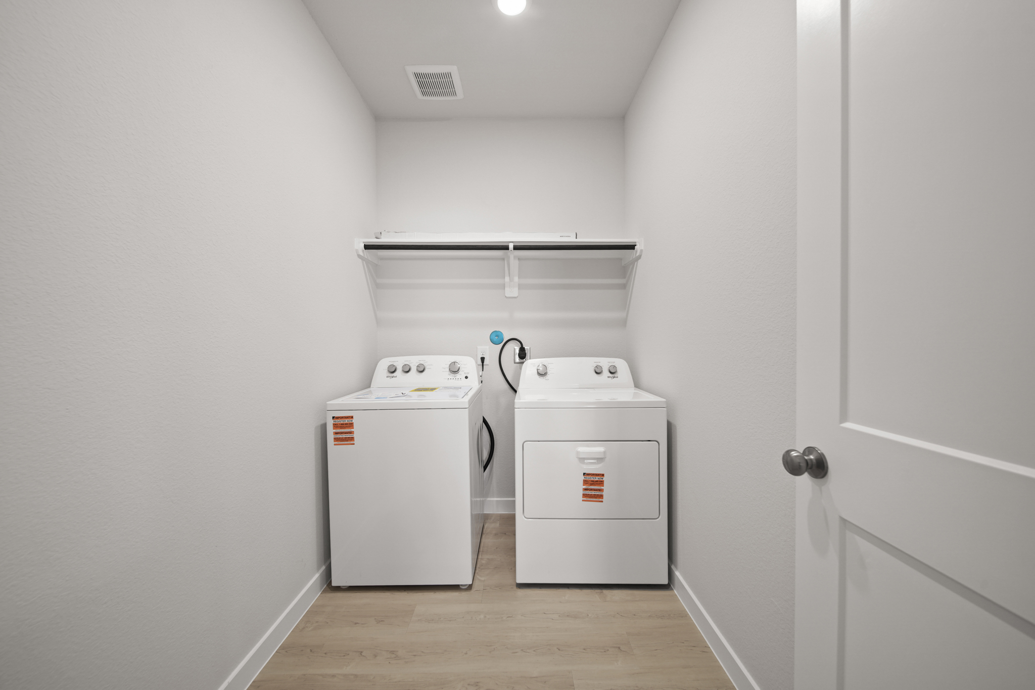 A white kitchen with a washer and dryer.