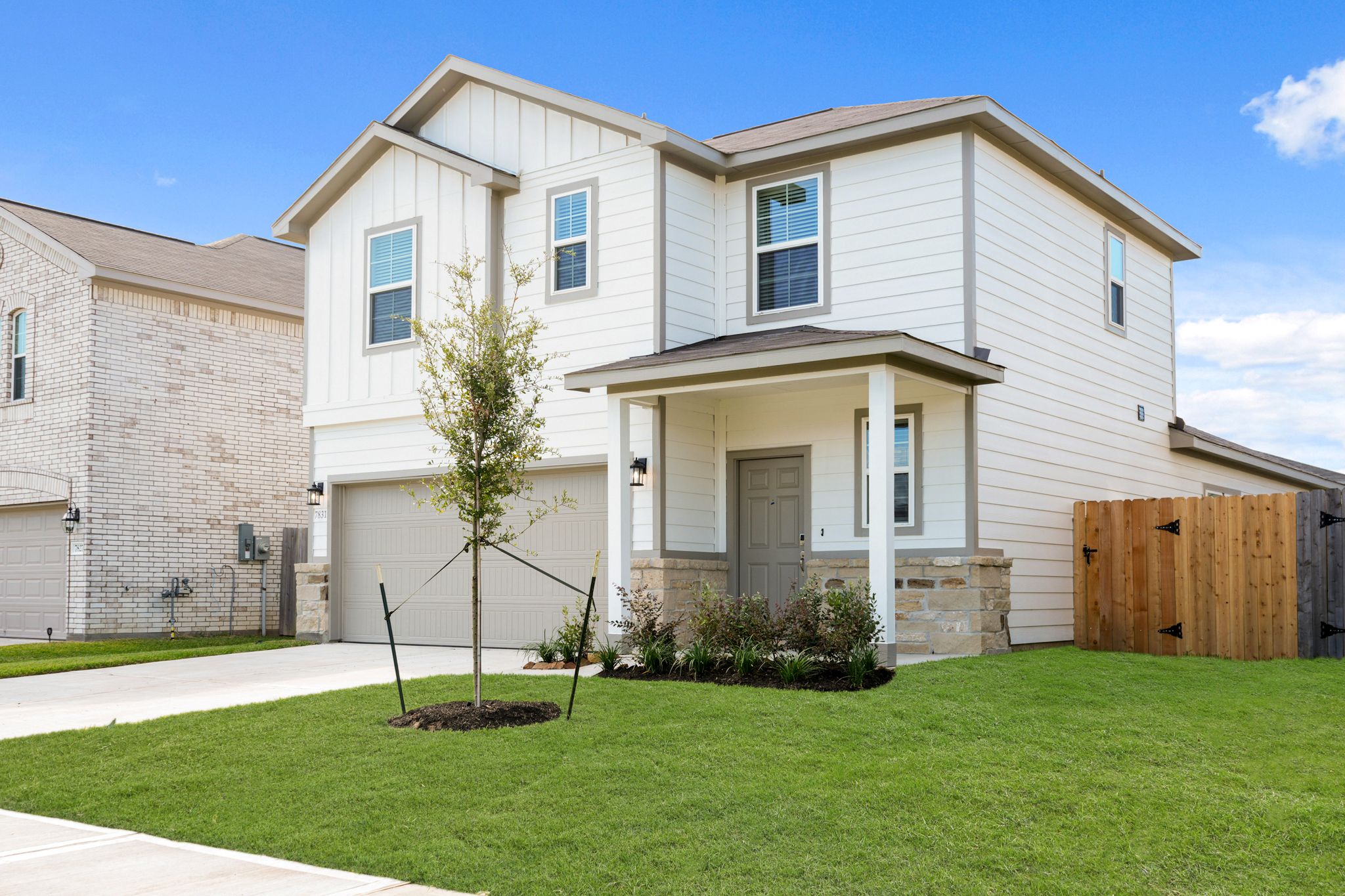 A house with a tree in the front yard.