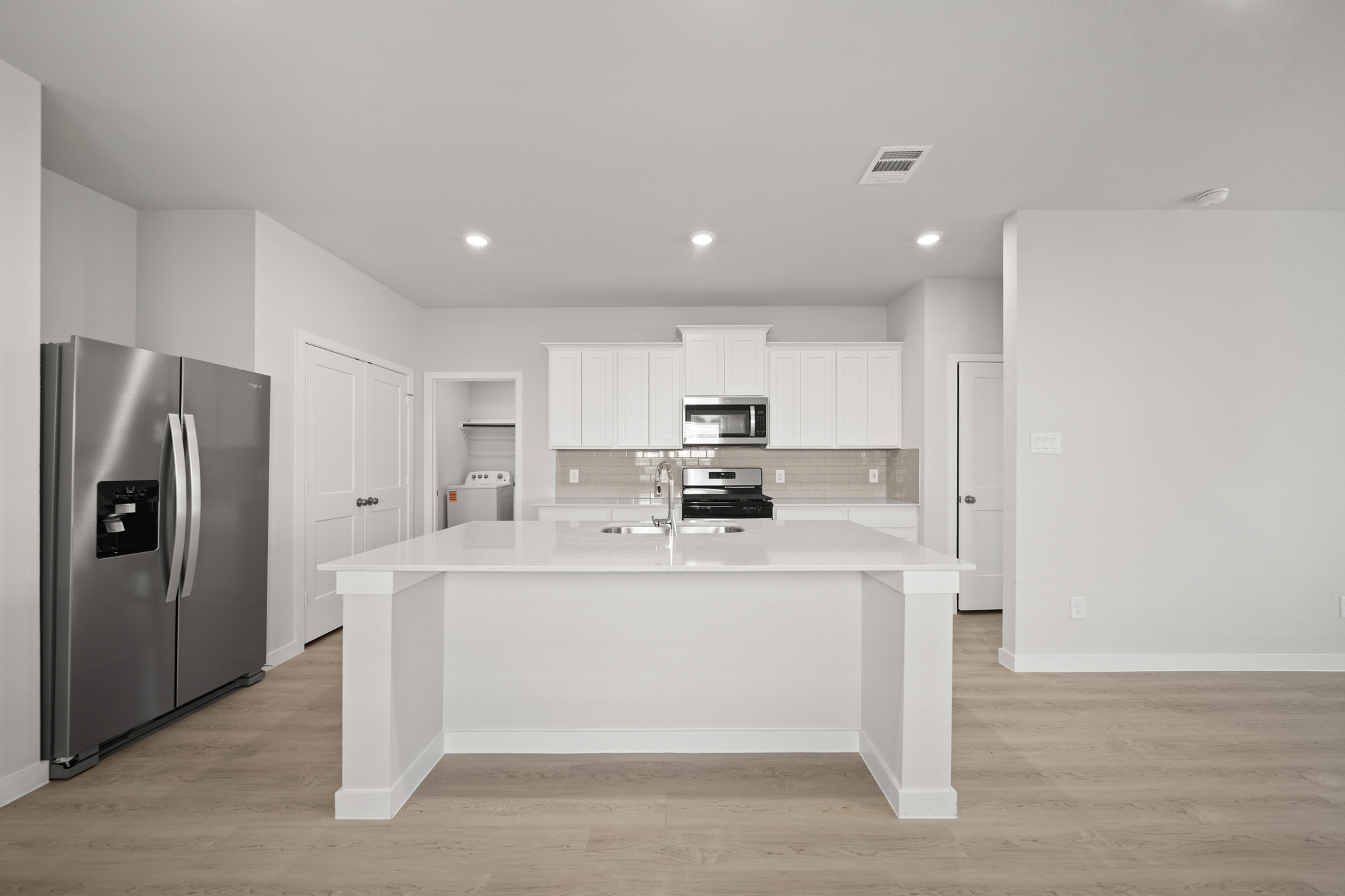 A kitchen with white cabinets.