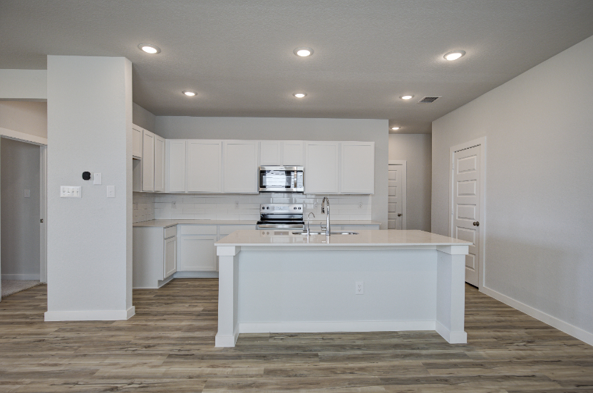 A kitchen with white cabinets.