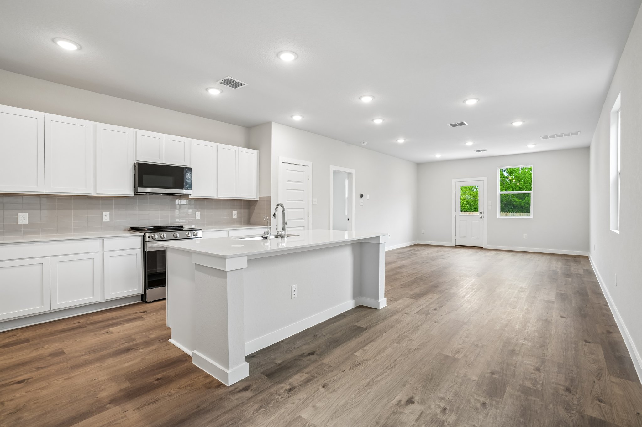 A kitchen with white cabinets.
