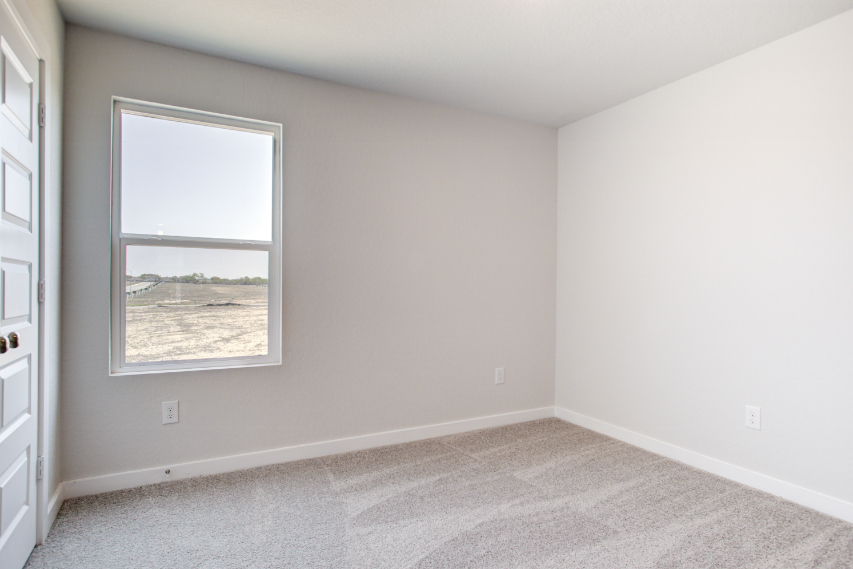 A room with a window and a carpet.