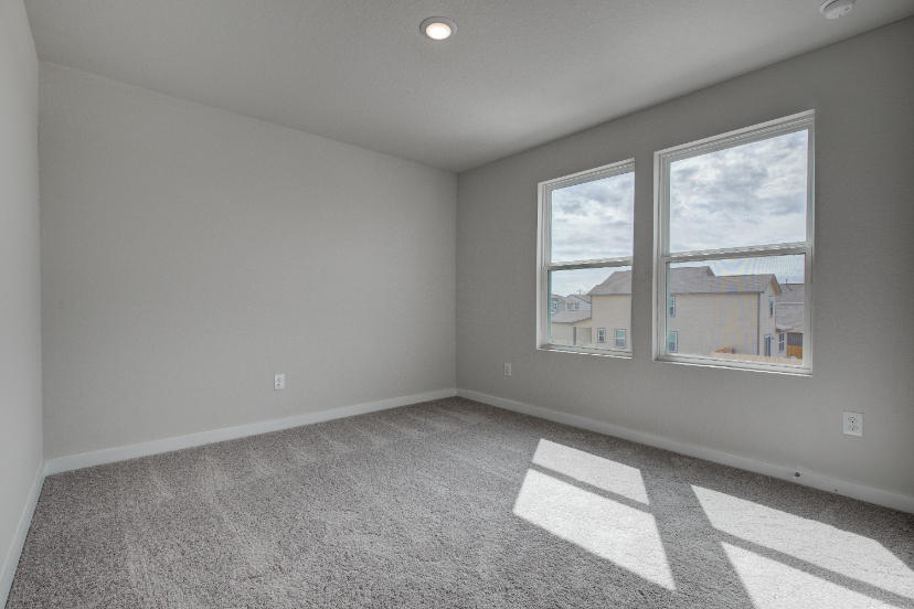 A room with a window and a rug.