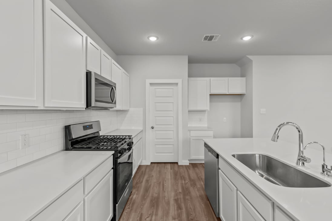 A kitchen with white cabinets.