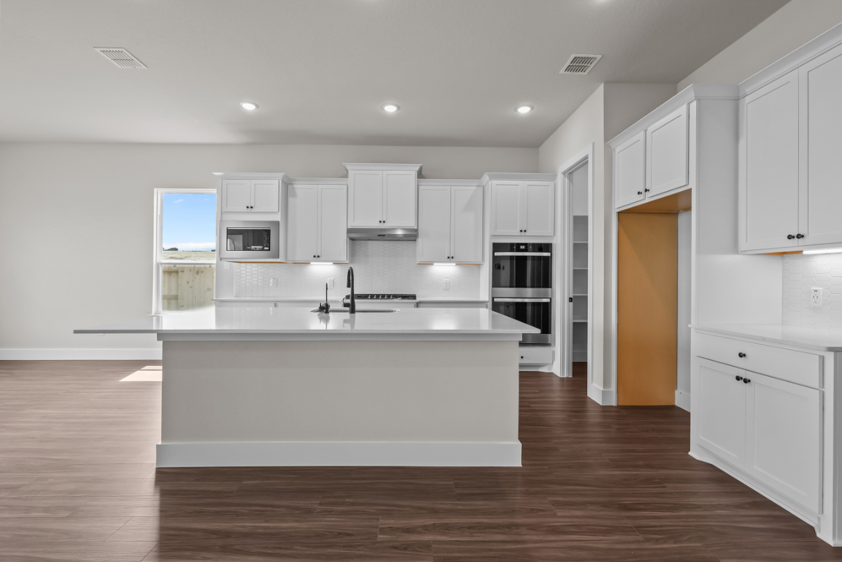 A kitchen with white cabinets.