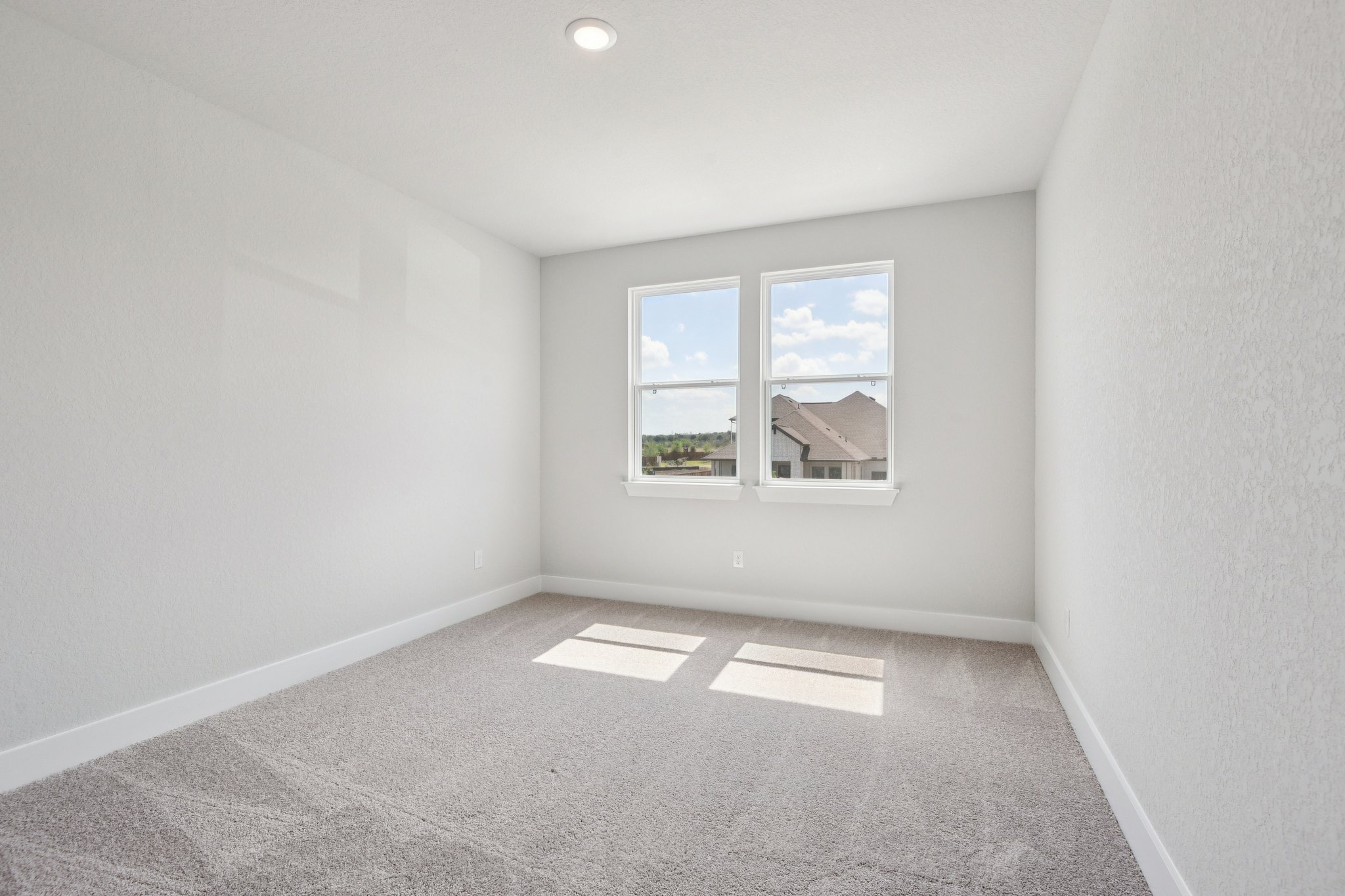 A room with a window and a carpet.