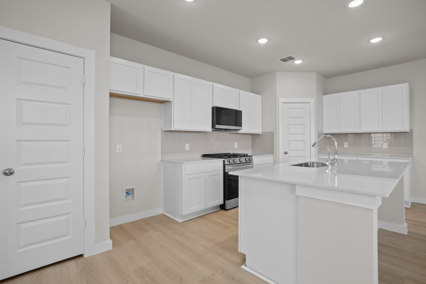 A kitchen with white cabinets.
