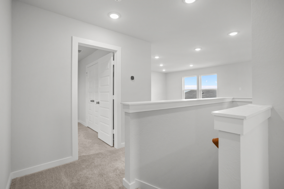 A white bathroom with a white countertop and a window.