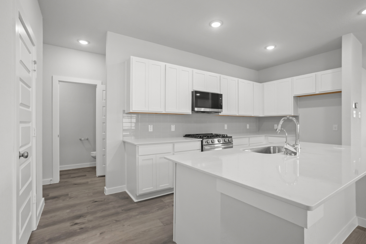 A kitchen with white cabinets.