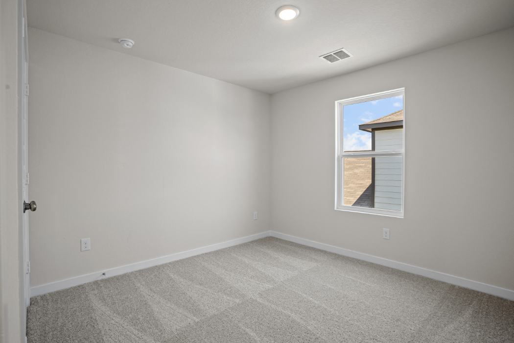 A room with a window and a carpet.