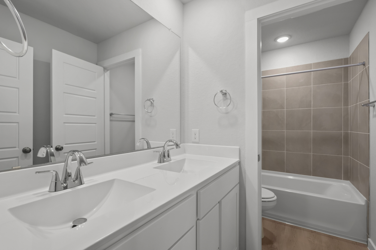 A bathroom with a tub sink and a toilet.