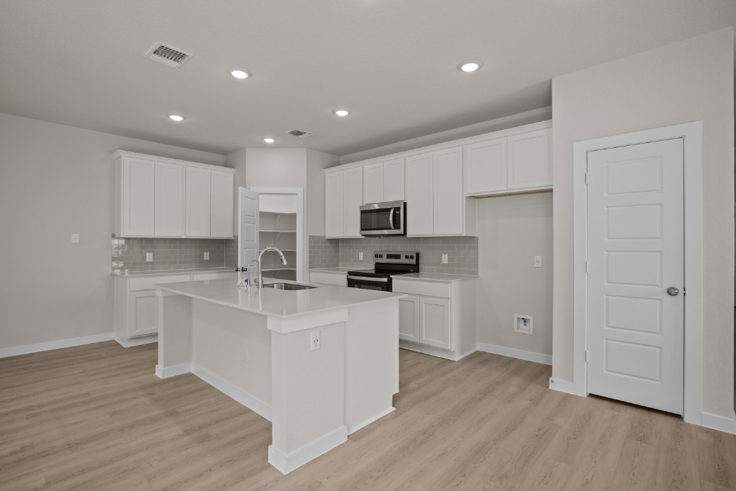 A kitchen with white cabinets.