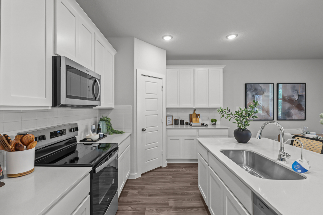 A kitchen with white cabinets.