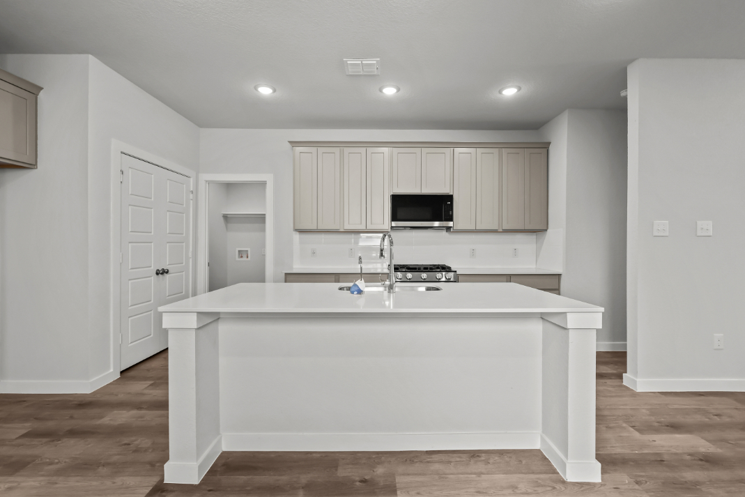 A kitchen with white cabinets.