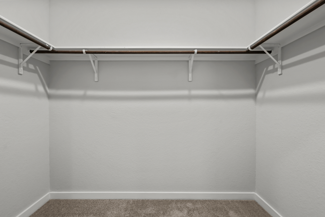 A white wall with a metal bar.