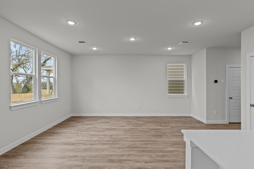 A room with a wood floor and windows.