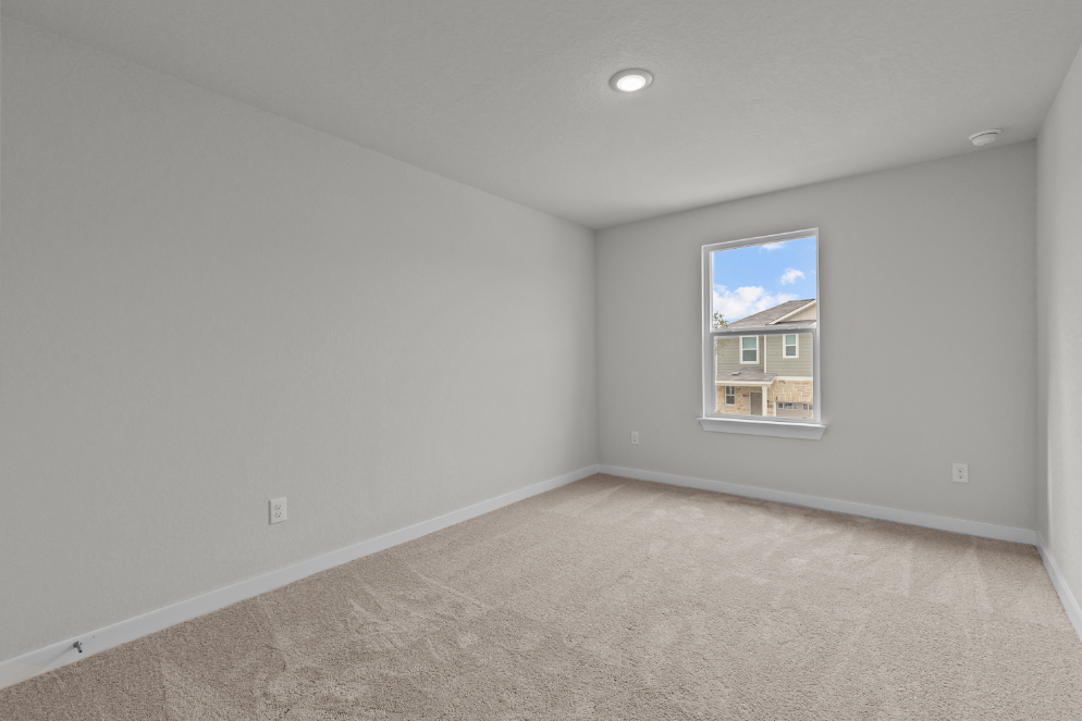 A room with a window and a carpet.